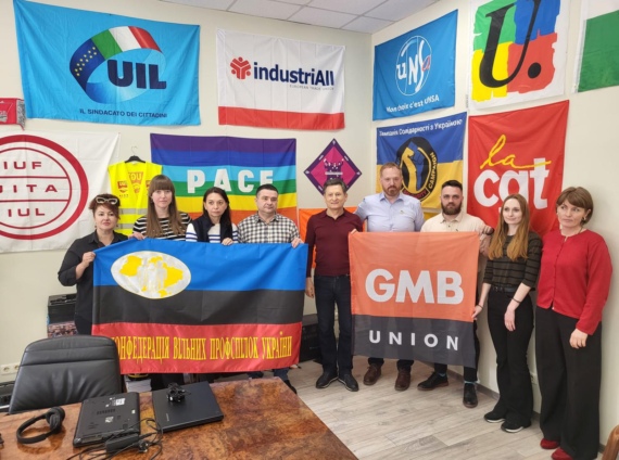 A GMB delegation and KVPU delegation hold respective banners in an office